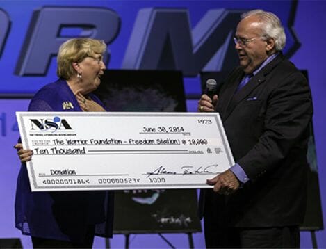 Layer 58 Elderly woman gratefully receiving a large check for $10,000 from the NSA Foundation