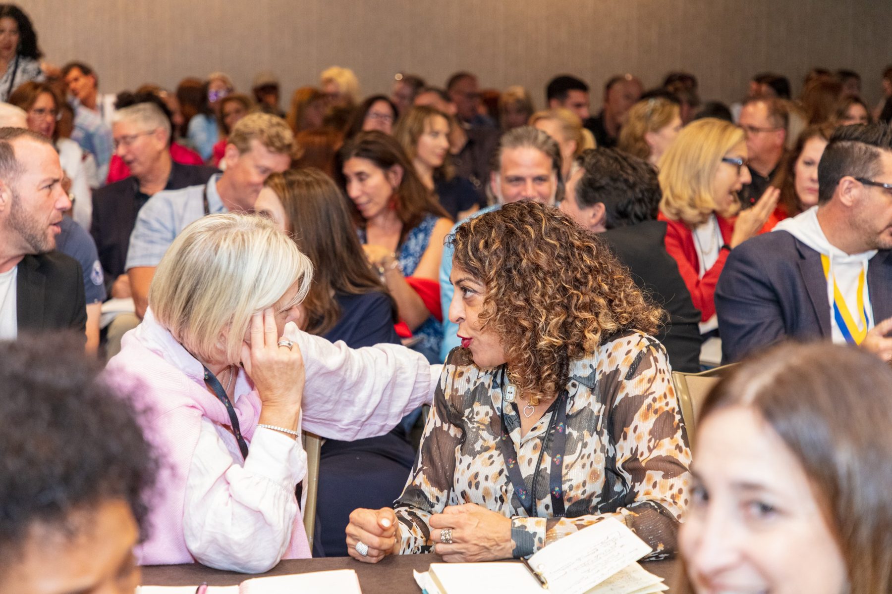 NSA members talking and taking notes together at round tables during a session